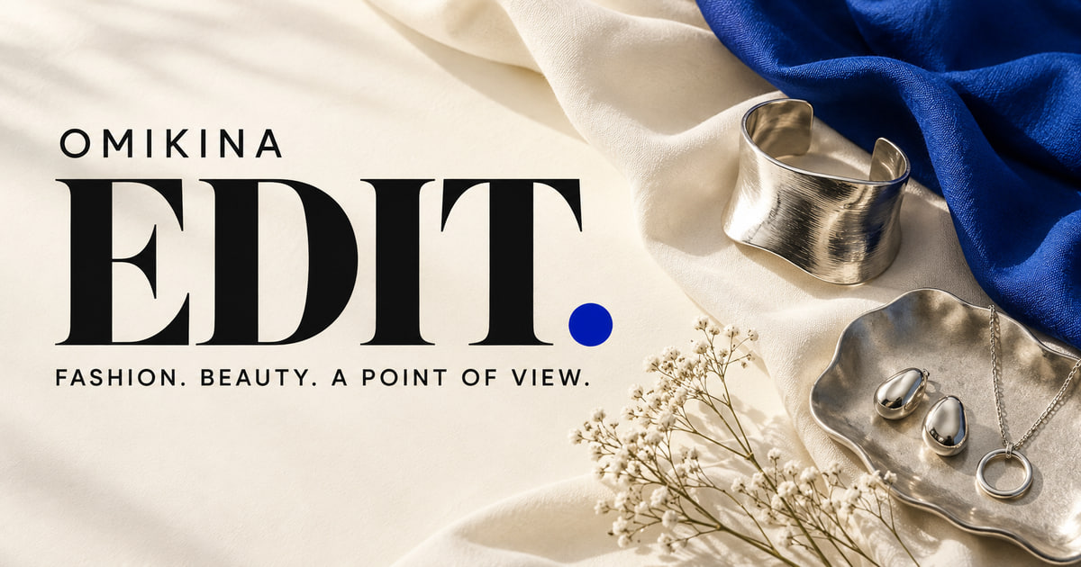 OMIKINA EDIT launch artwork, an AI-generated fashion still life in ivory, cobalt and silver.